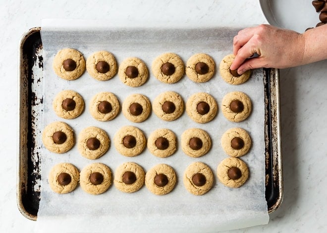An easy Peanut Butter Blossoms cookie recipe. Soft, chewy peanut butter cookies are rolled in sugar, baked, and topped with a single Hershey's kiss!