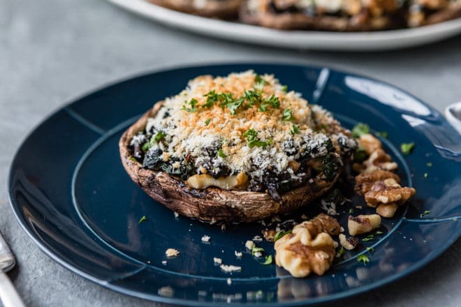 A Stuffed Portobello Mushroom on a navy blue plate.