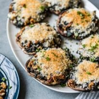 Stuffed portobello mushrooms on a white platter.