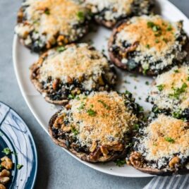 Stuffed portobello mushrooms on a white platter.