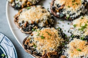 Stuffed portobello mushrooms on a white platter.