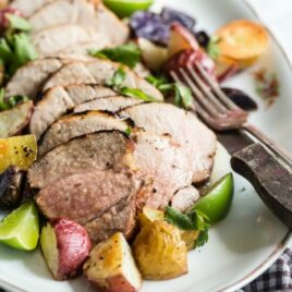 Grilled pork tenderloin slices on a white platter.