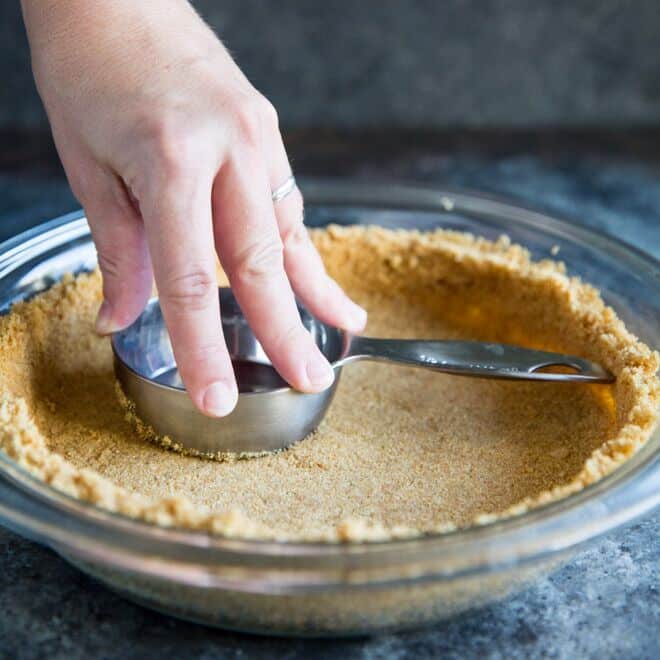 Someone making a graham cracker crust.