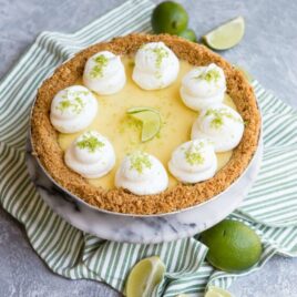 A key lime pie on a striped table linen.