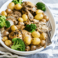 Pesto roasted chicken in a white serving dish.