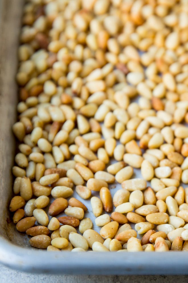 Toasted pine nuts on a baking sheet.