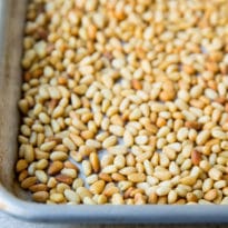 Toasted pine nuts on a baking sheet.