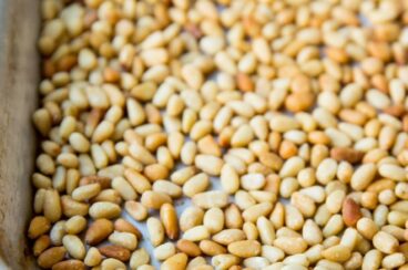 Toasted pine nuts on a baking sheet.
