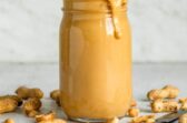 Homemade peanut butter in a clear jar.