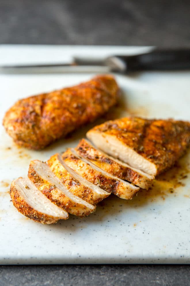 Sliced grilled chicken on a gray counter top.