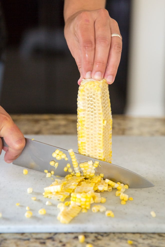 Corn being cut off of a cob.