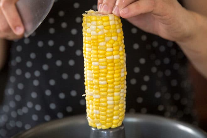 Corn being cut off of a cob.