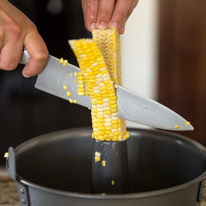 Corn being cut off of a cob.