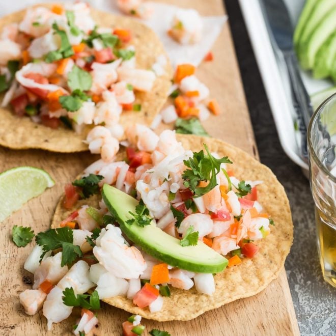 A closeup angled shot of shrimp ceviche on a wood cutting board.