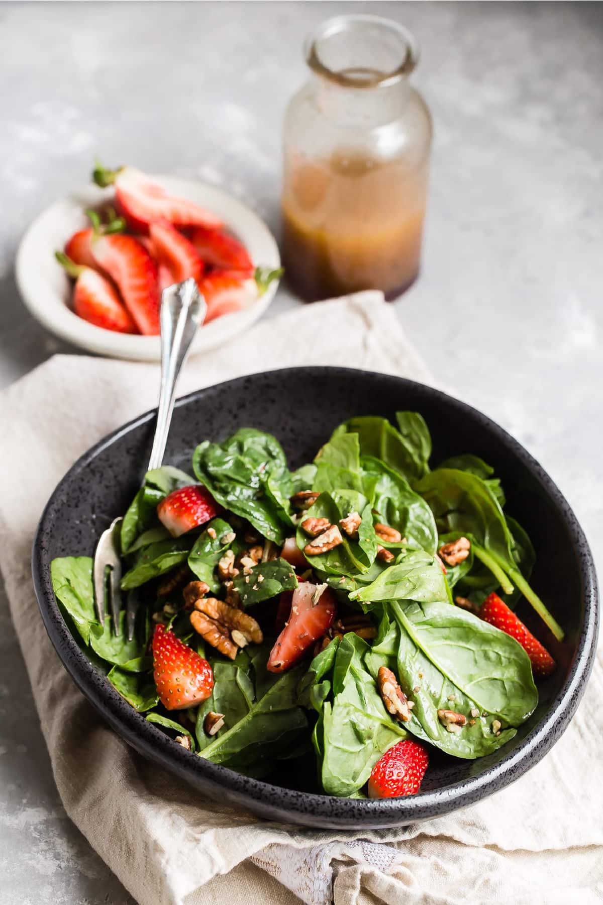 A bowl of strawberry spinach salad.