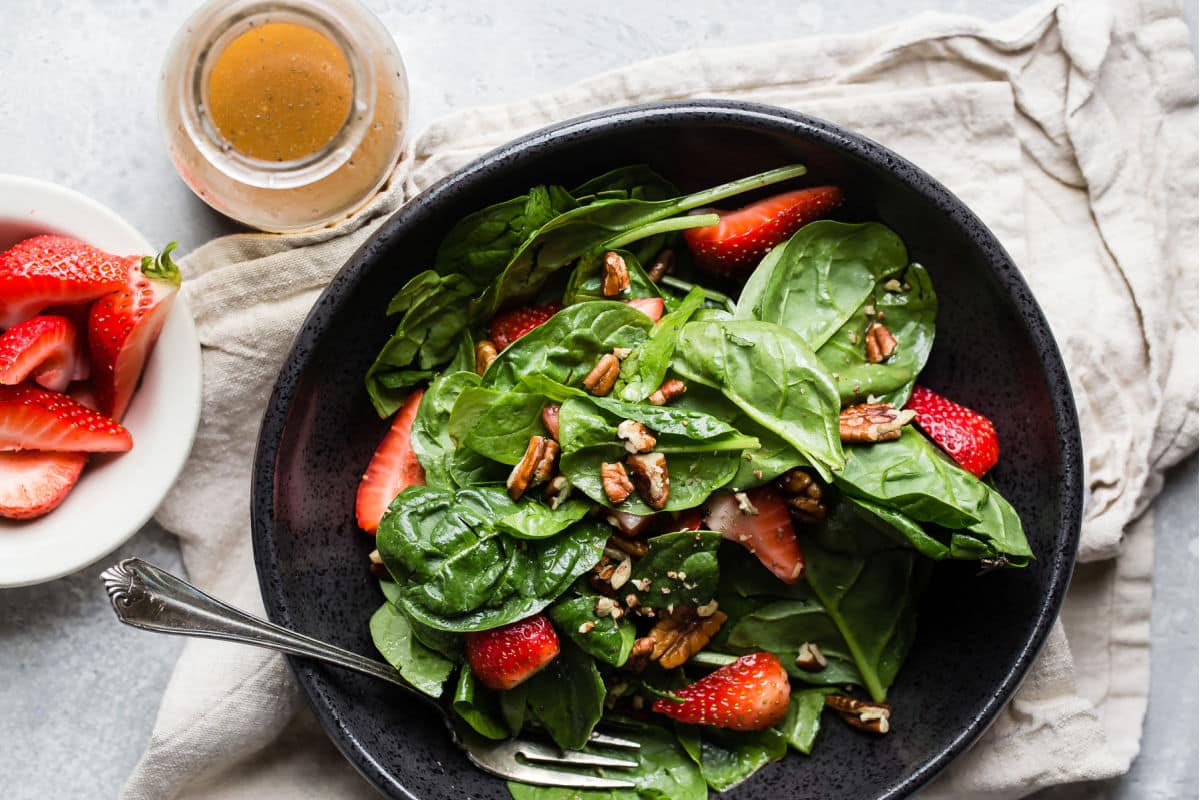 A bowl of strawberry spinach salad.