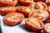 Roasted tomato halves in a baking pan.