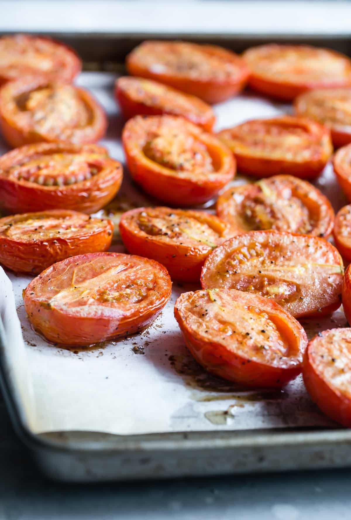 Roasted tomatoes on a baking sheet.