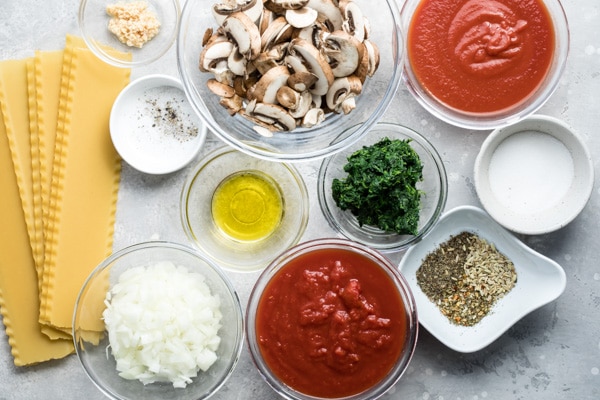 Vegetable lasagna ingredients in various bowls.