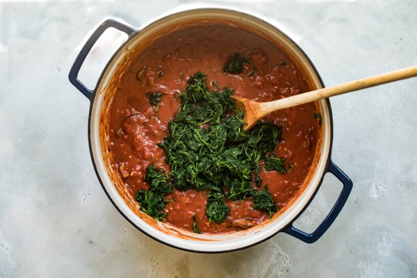 Vegetable lasagna sauce cooking in a blue pot.