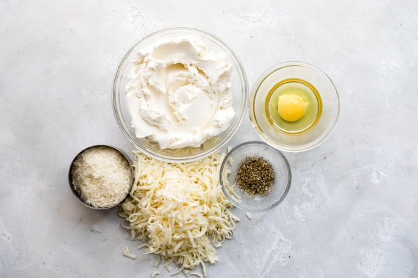 Vegetable lasagna ingredients in various bowls.
