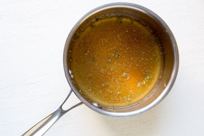 Condensed cream of chicken soup ingredients cooking in a silver pot.
