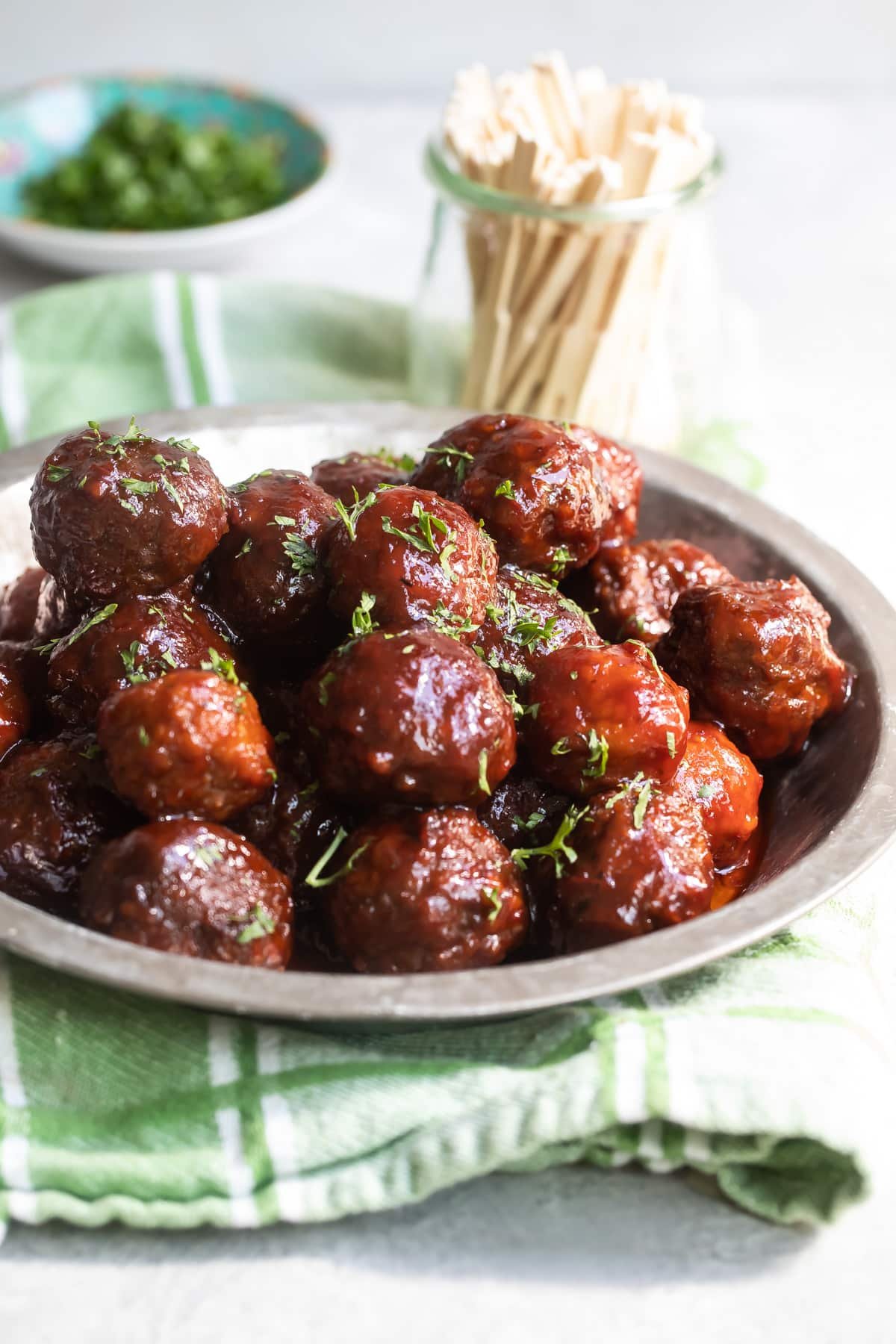 Crockpot meatballs with grape jelly sauce in a silver bowl.