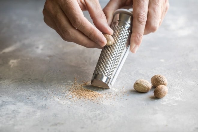 Nuts being shaved with a zester.