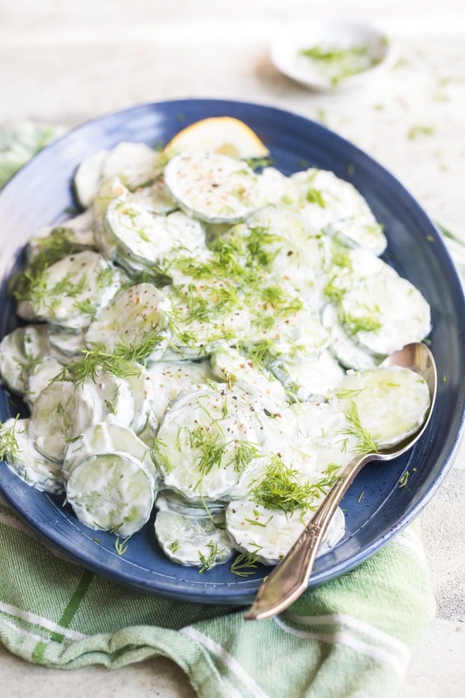 Creamy cucumber salad on a blue plate.