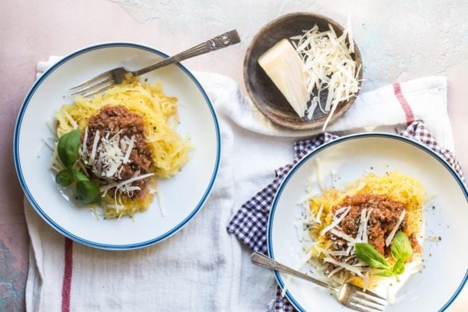 Spaghetti squash with homemade meat sauce on white plates.