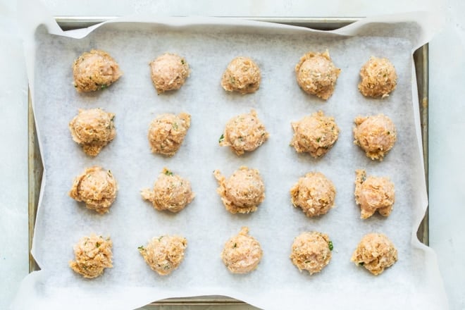 Chicken meatballs on a baking sheet.