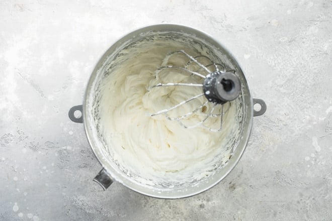 Cream cheese frosting in a silver mixing bowl.