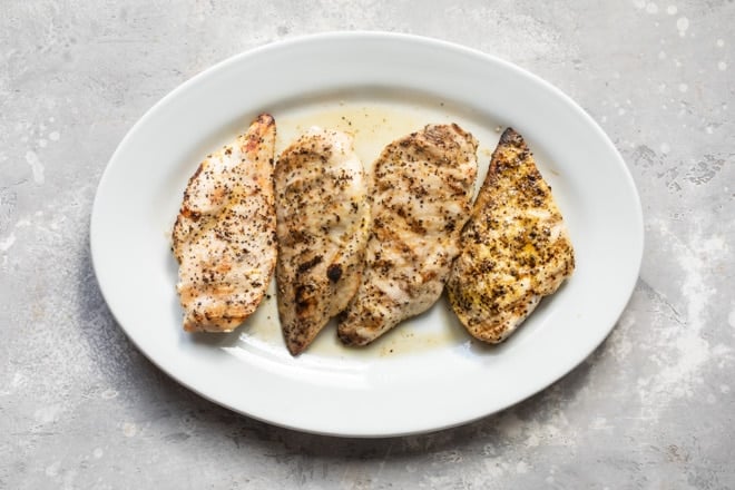 Lemon pepper chicken on a white platter.