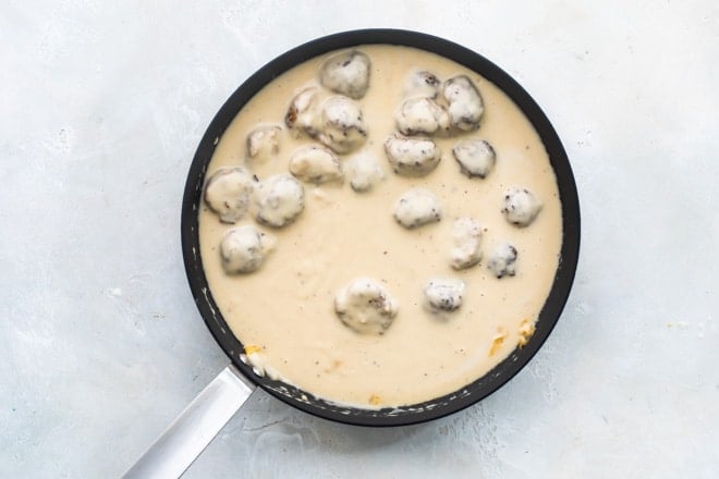 Swedish meatballs in creamy gravy in a skillet.