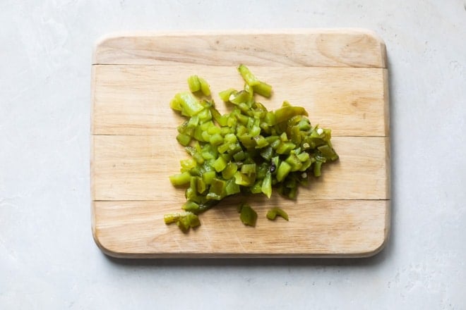 Poblano pepper on a wood cutting board.