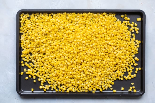 Corn on a baking sheet.