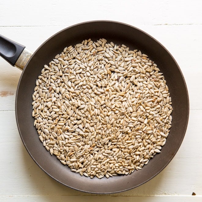 Sunflower seeds in a black frying pan.