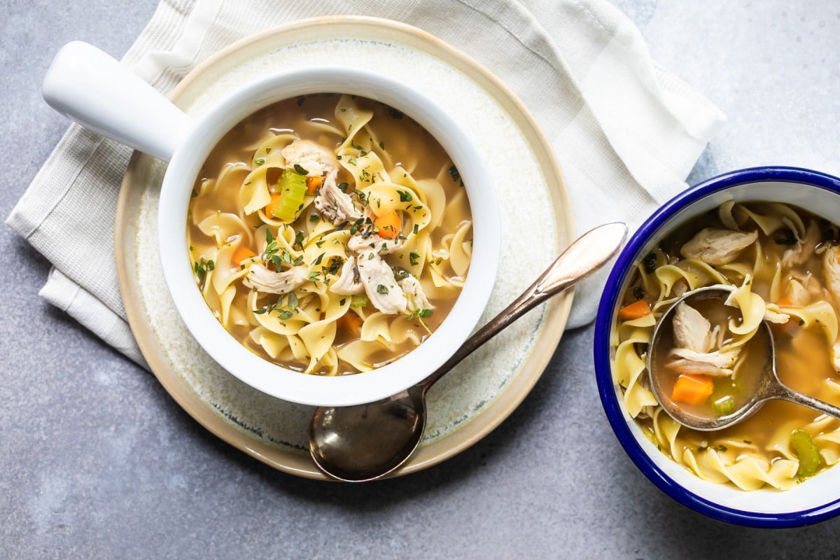 Chicken noodle soup in a white bowl.