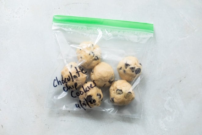 Balls of chocolate chip cookie dough in a plastic bag and labeled for the freezer.
