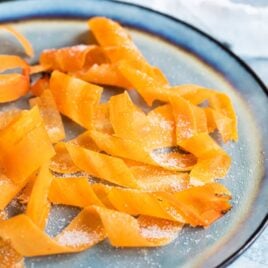 Candied carrot curls on a blue plate.