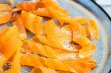 Candied carrot curls on a blue plate.