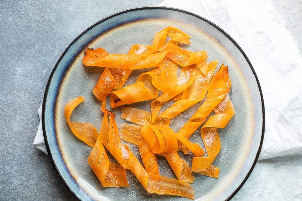 Candied carrot curls on a blue plate.