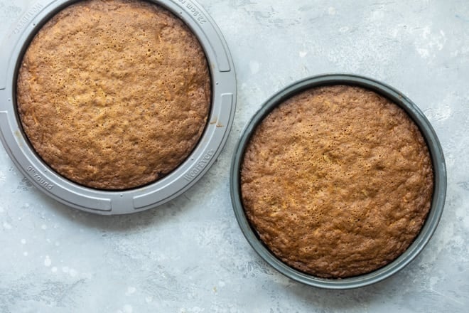 Two carrot cake layers in round baking pans.