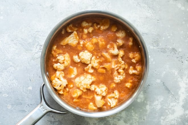 Cauliflower tinga taco filling cooking in a silver pan.