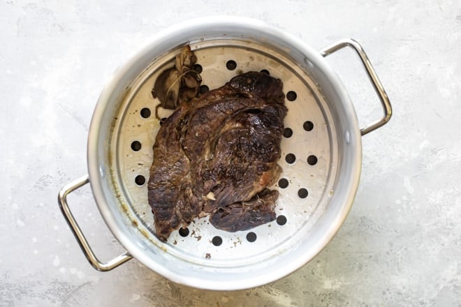 Cooked birria in a colander.