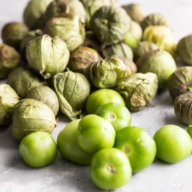 Tomatillos on a gray counter.