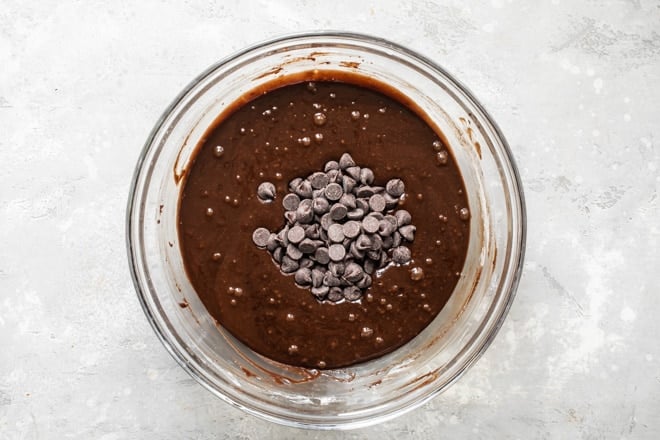 Brownie batter in a bowl with chocolate chips on top.