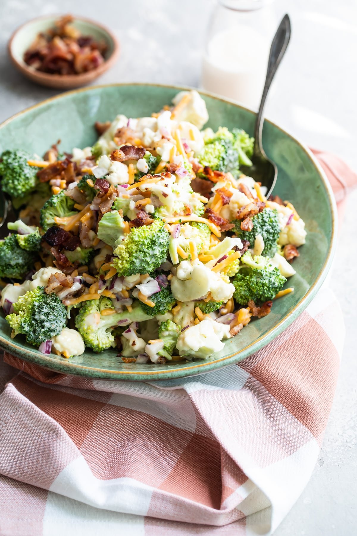 A bowl of broccoli salad with bacon and cheese.