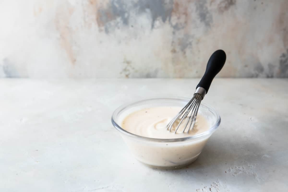 A bowl of salad dressing for broccoli salad.
