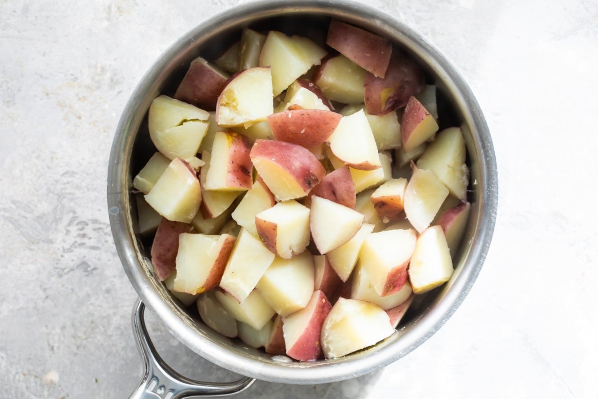 Boiled and cut potatoes in a pot.